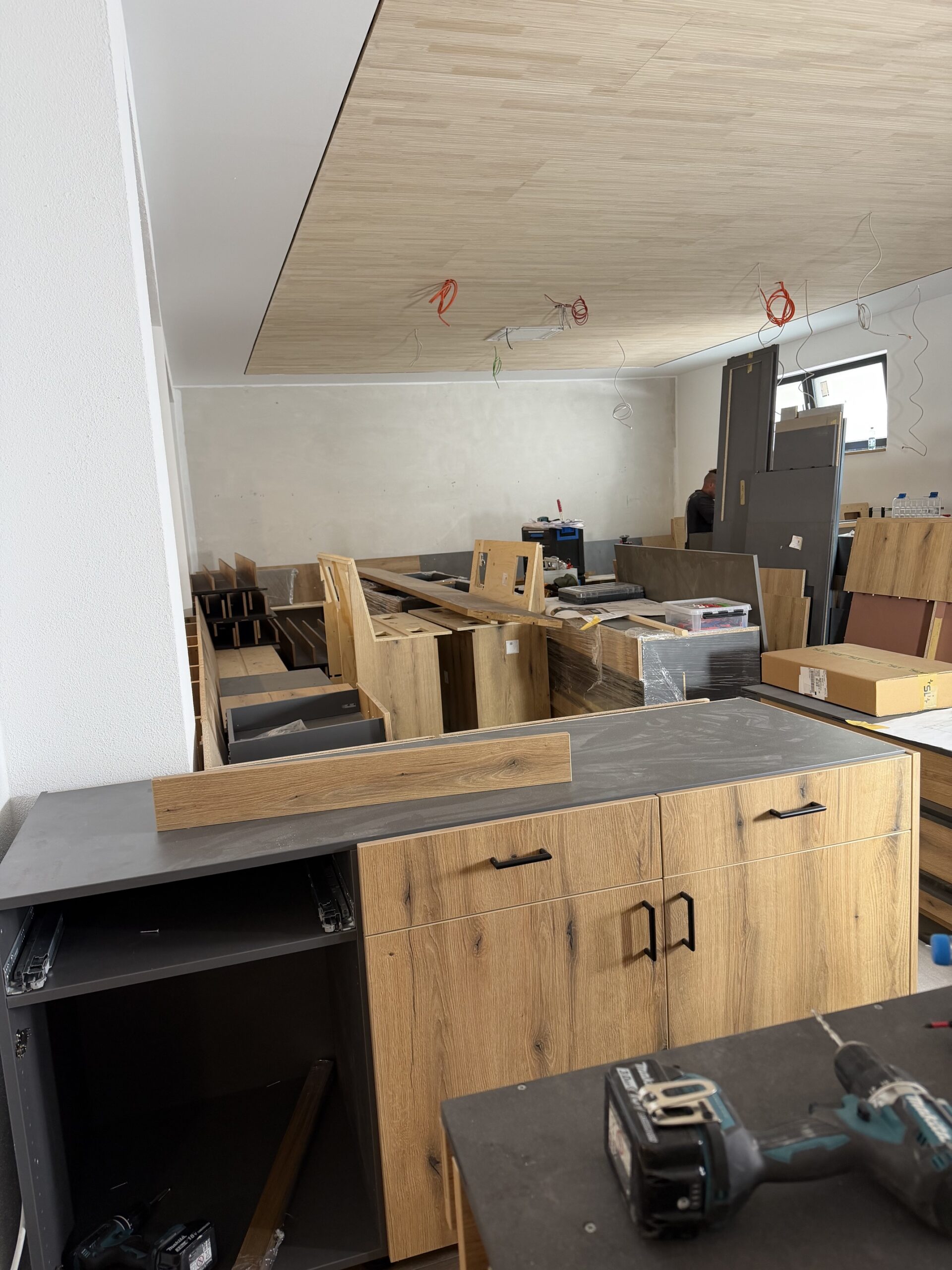 Möbelaufbau im neuen Frühstücksraum des Waldhotel Heppe – Eichenholz-Schränke mit anthrazitfarbenen Arbeitsplatten werden montiert, Holzdecke bereits fertiggestellt